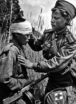 Cанинструктор В.И. Кемаева перевязывает раненого бойца на Воронежском фронте